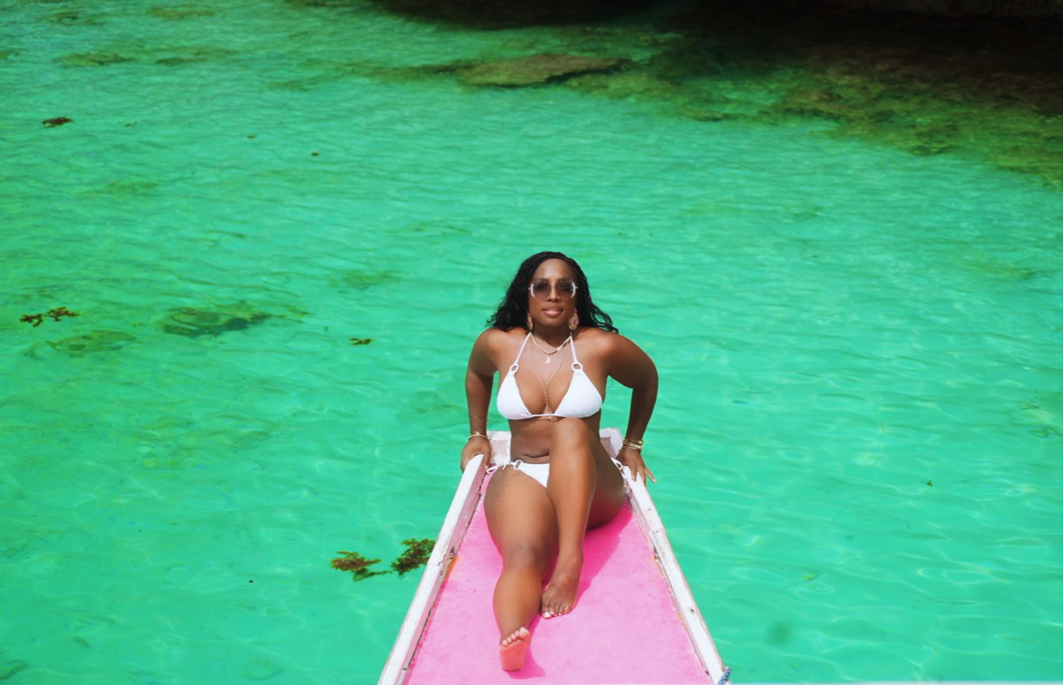 Jaymie enjoying crystal clear turquoise water from a colorful boat