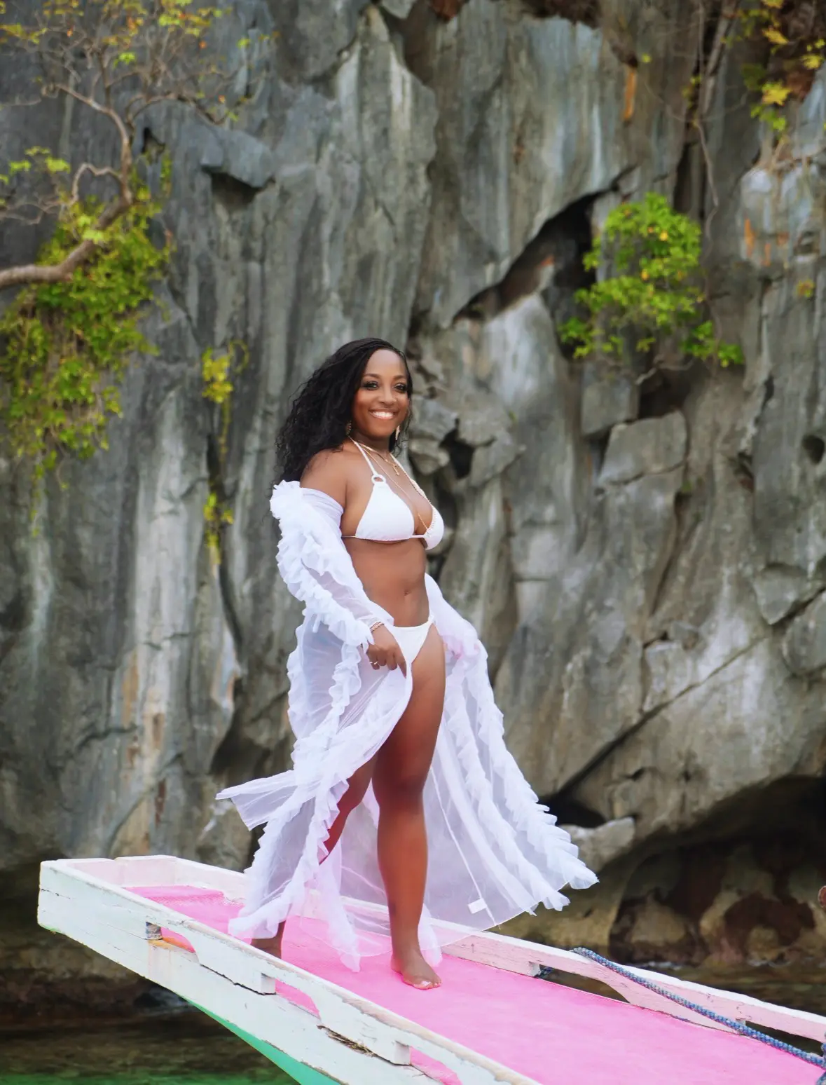 Jaymie standing confidently on a boat during an island escape